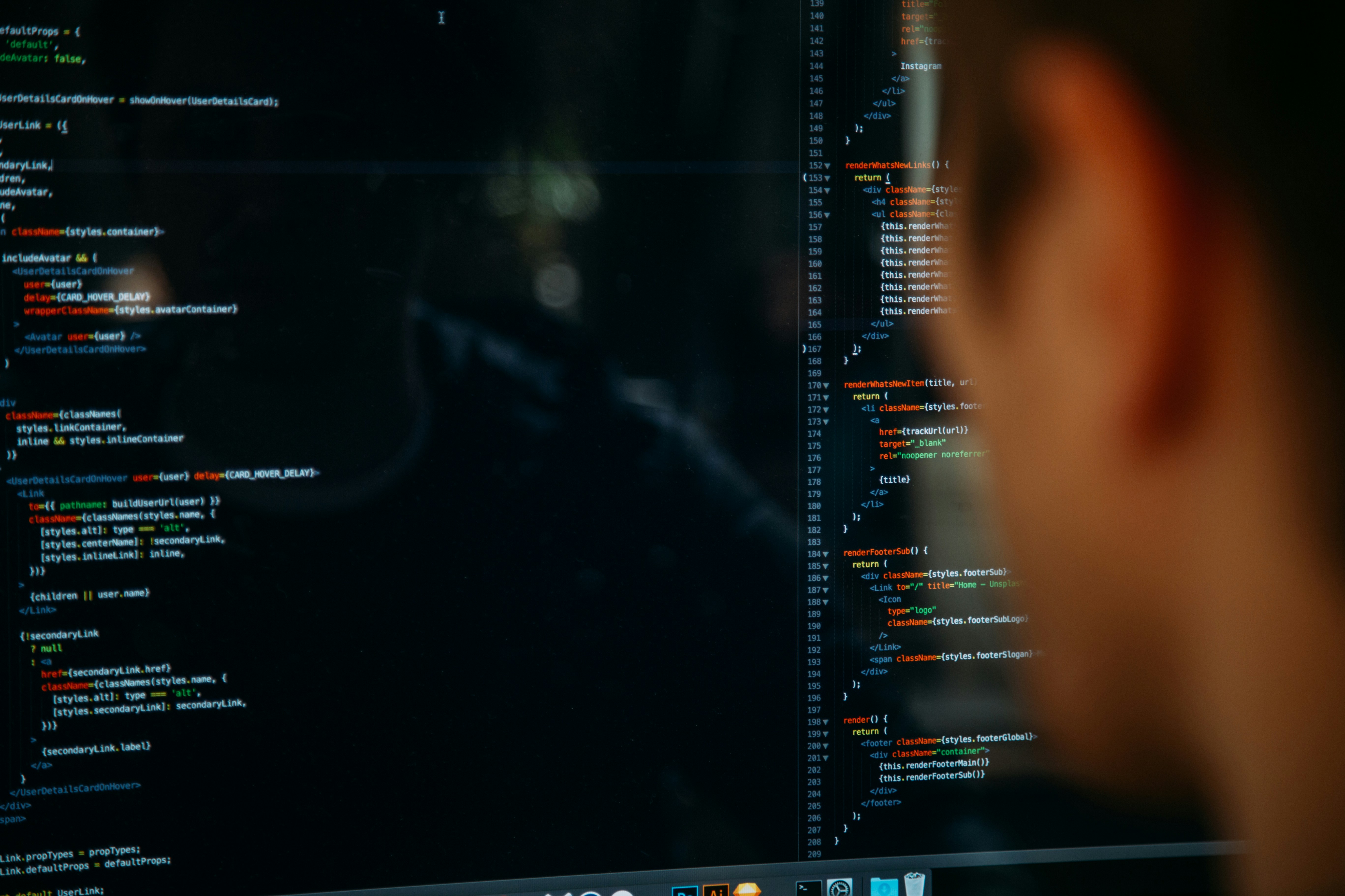 Developer working at a laptop in a dark workspace